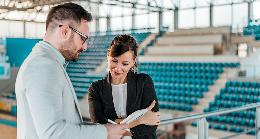 sports agents looking at paperwork in an arena